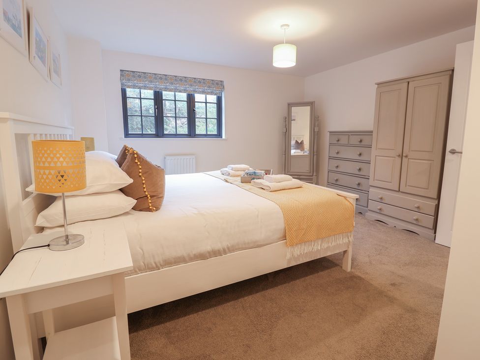 A bedroom with a double bed and furniture at Corner Cottage, Thorpeness