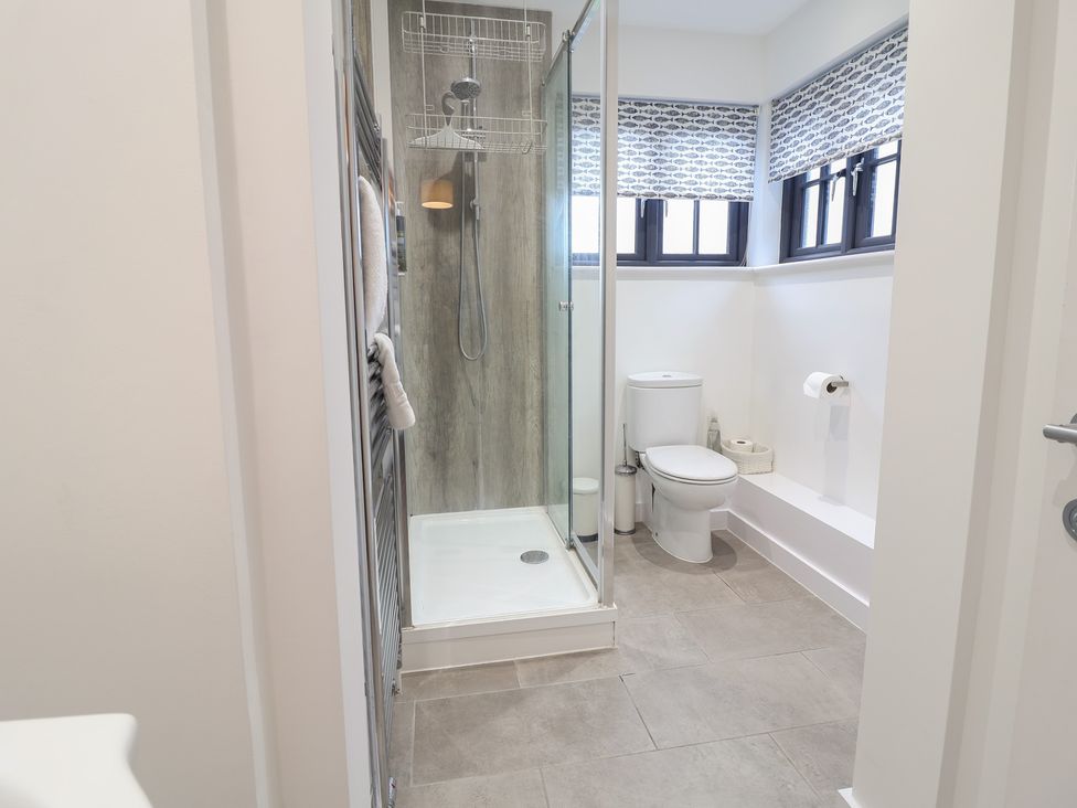 A bathroom with a shower and toilet at Corner Cottage, Thorpeness
