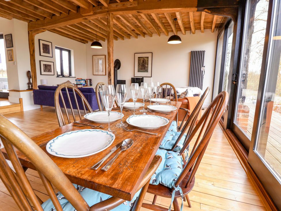 A dining room with a wooden table set for a meal at Fishpond House, Halesworth