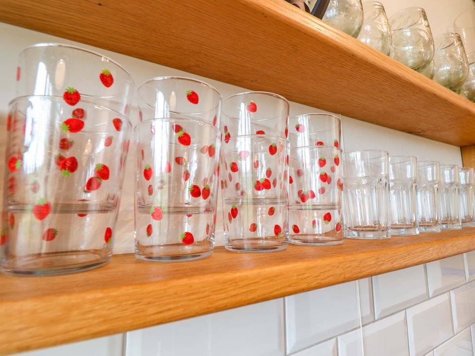 Glasses with strawberry print on a wooden shelf at Fishpond House, Sotherton