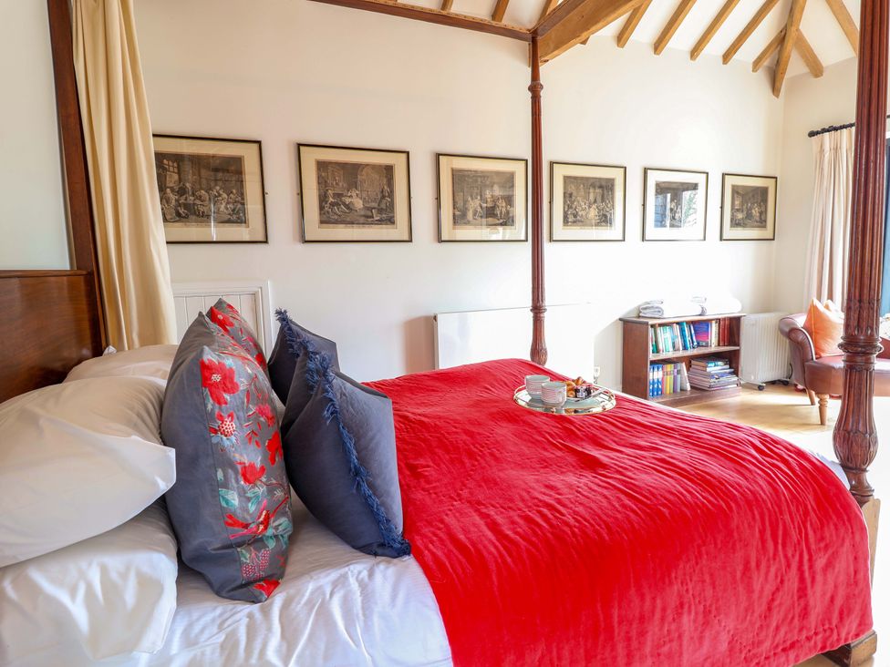 A bedroom with a four-poster bed and artwork at Fishpond House, Sotherton