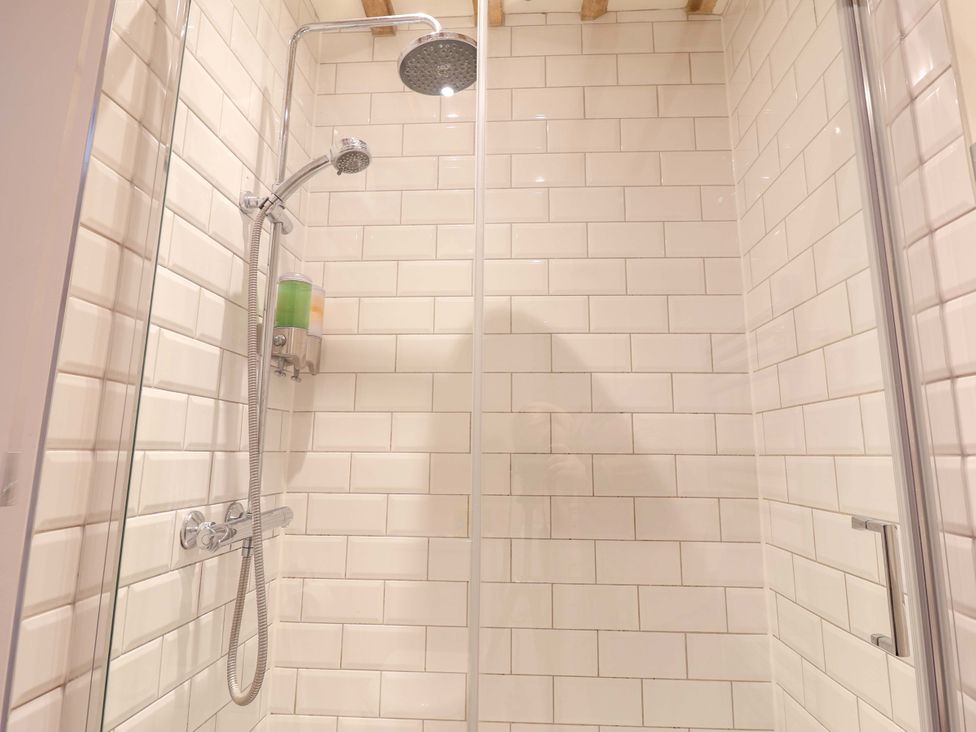 A shower with a wall and soap dispenser at Fishpond House, Sotherton
