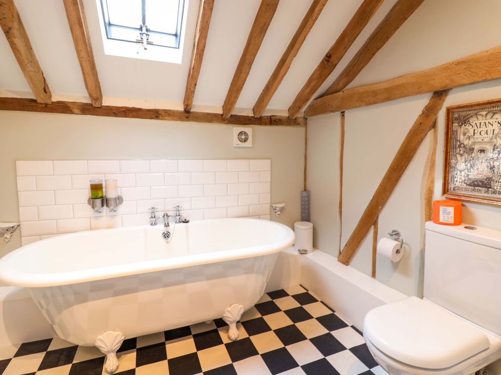 A bathroom with a bathtub and toilet at Fishpond House, Sotherton Halesworth