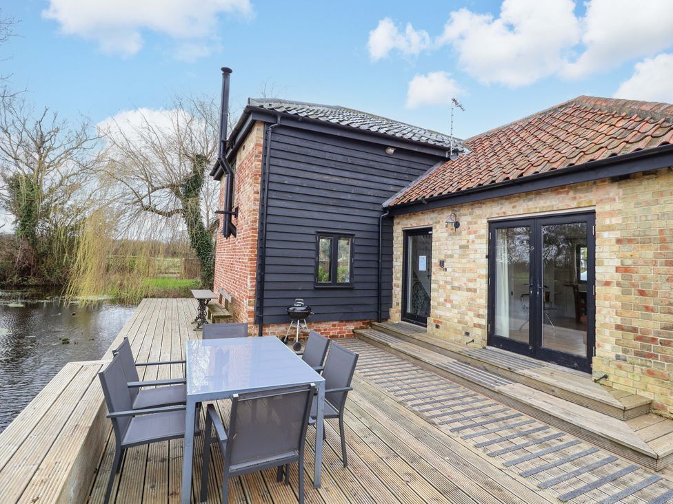An outdoor area with a table and chairs at Fishpond House, Sotherton Halesworth