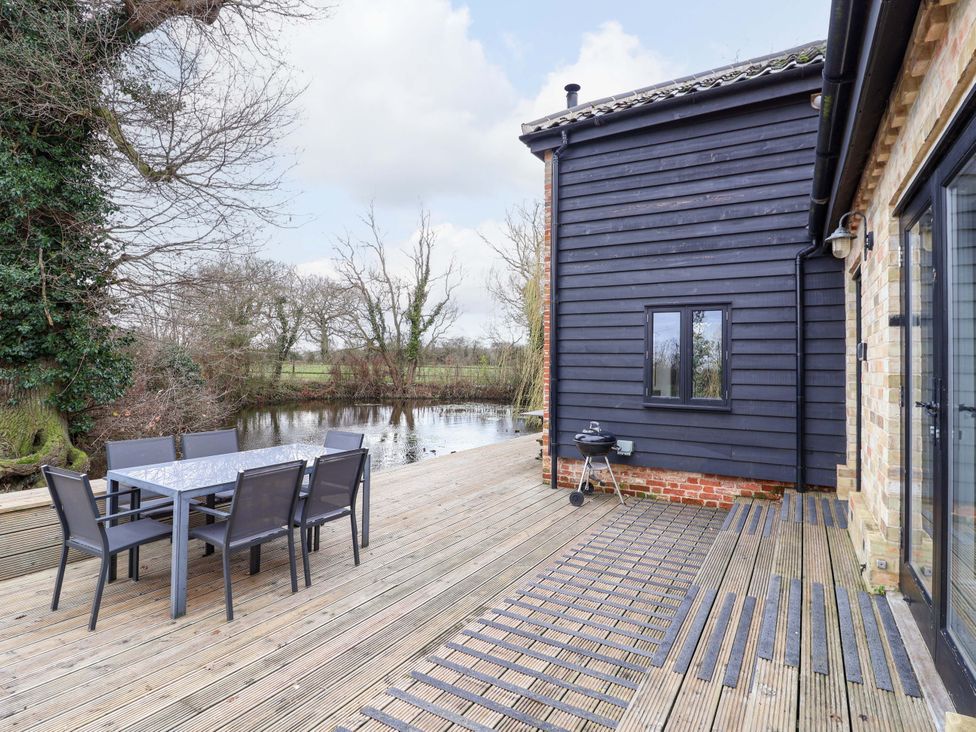 An outdoor dining area with a table and chairs at Fishpond House, Sotherton Halesworth