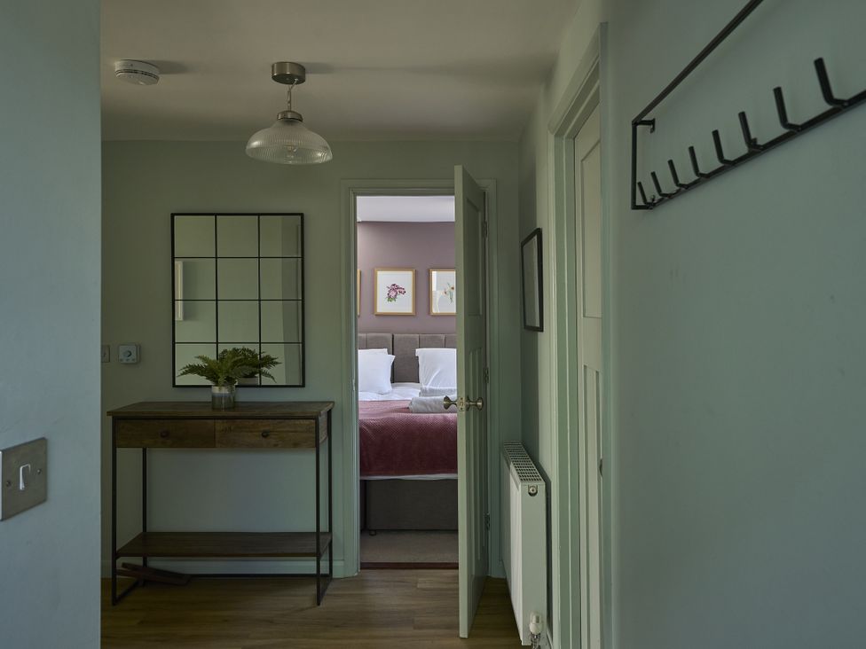 A hallway with a console table and mirror at Harbour Lights in Southwold