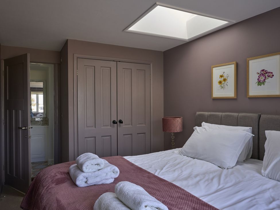 A bedroom with a bed and wardrobe at Harbour Lights in Southwold