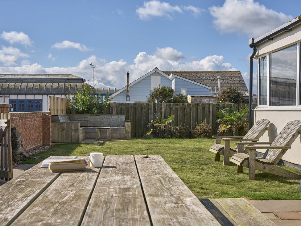 A garden with a table and chairs at Harbour Lights in Southwold