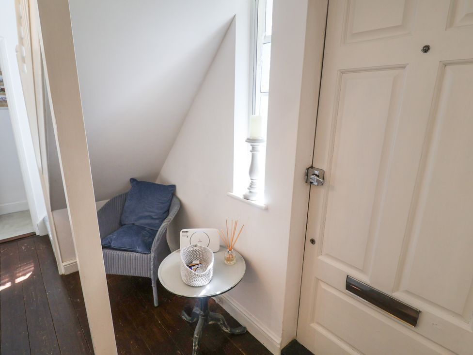 A hallway with a chair and table at High Ground, Reydon