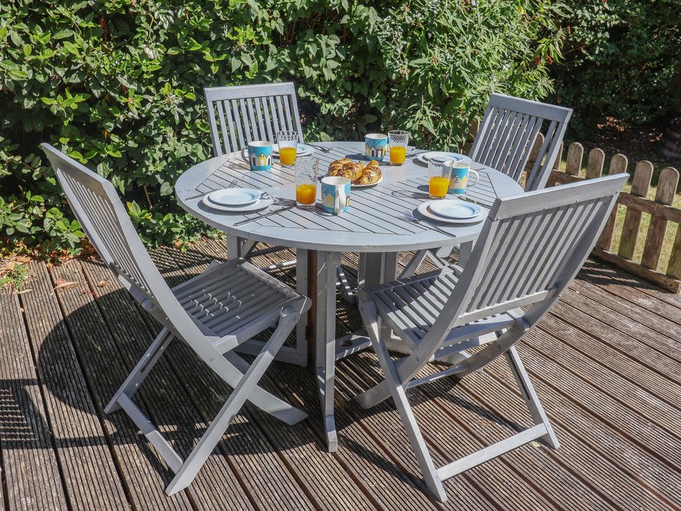 A garden dining table with cups and plates at High Ground, Reydon