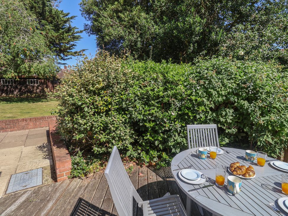 A garden with a table set for breakfast at High Ground, Reydon