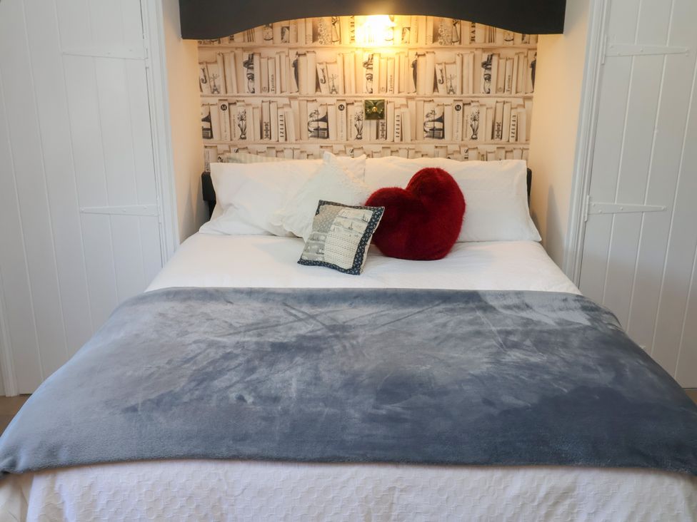 A bedroom with a bed and decorative pillows at Cherry Tree Cottage, Woodbridge