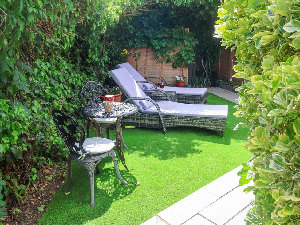 A garden with lounge chairs and a table at Cherry Tree Cottage, Woodbridge