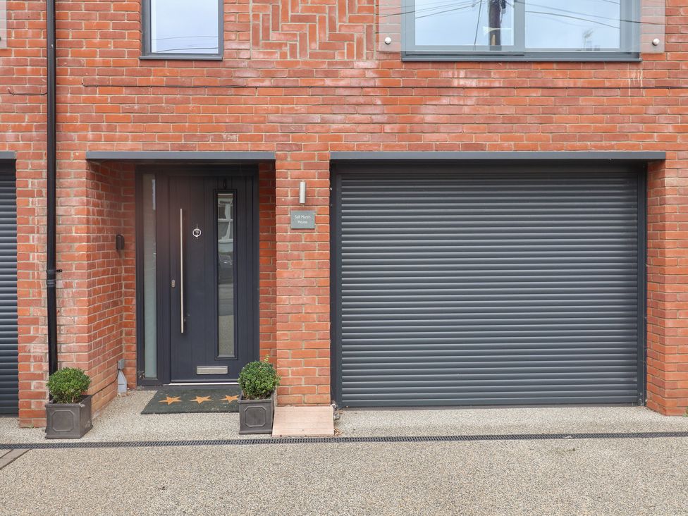 A front entrance with a door and garage door at Salt Marsh House, Southwold