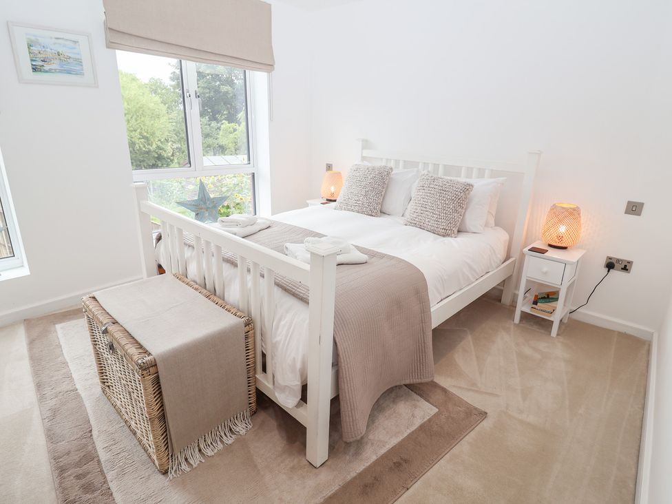 A bedroom with a bed and bedside table at Salt Marsh House, Southwold