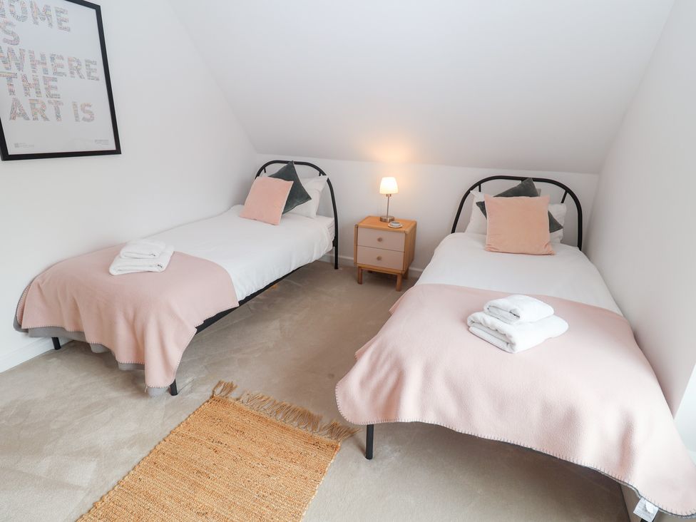 A bedroom with two single beds and a nightstand at Salt Marsh House, Southwold