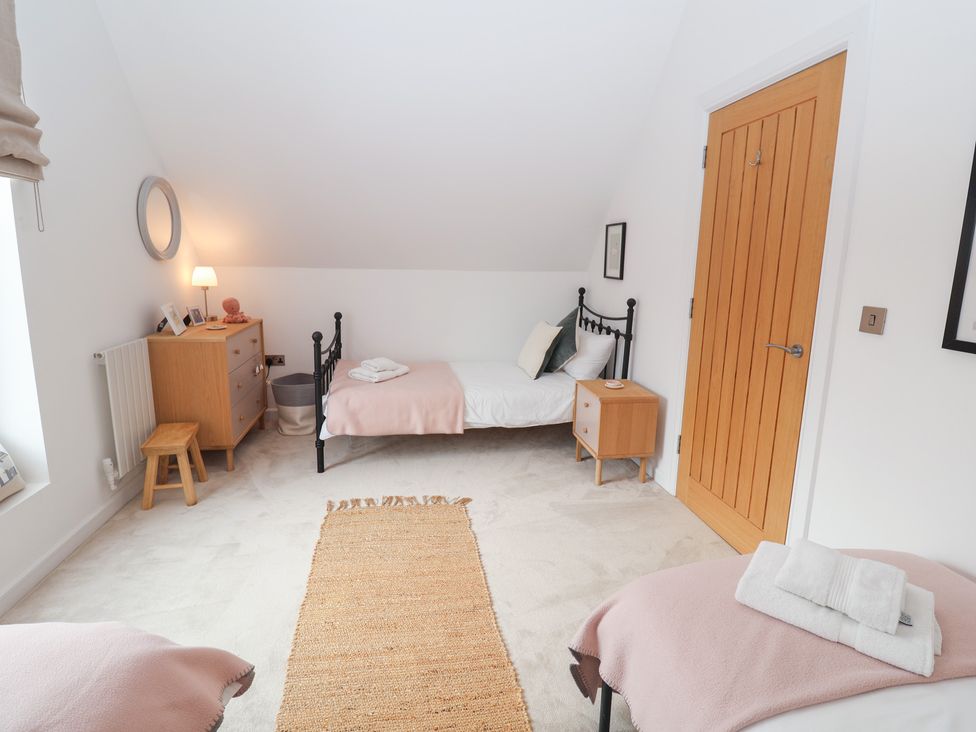 A bedroom with two beds and a dressing table at Salt Marsh House, Southwold