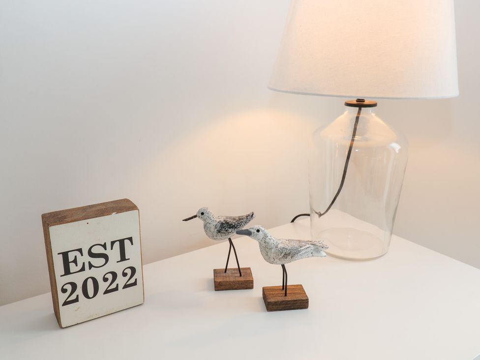 A table with birds, lamp and a block with EST 2022 at Salt Marsh House, Southwold