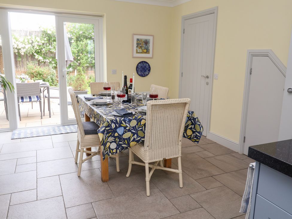 A dining room with a table set for dinner at 1 Coconut Cottage, Long Melford