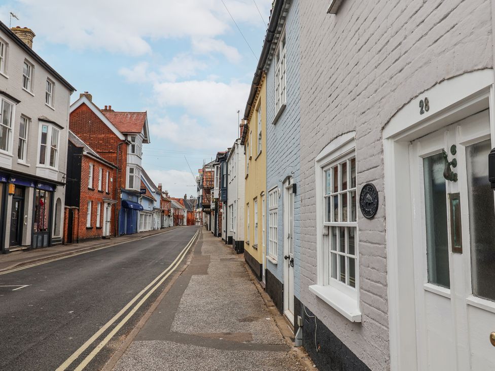 A street with brick buildings painted in various colors and closed shops in Southwold