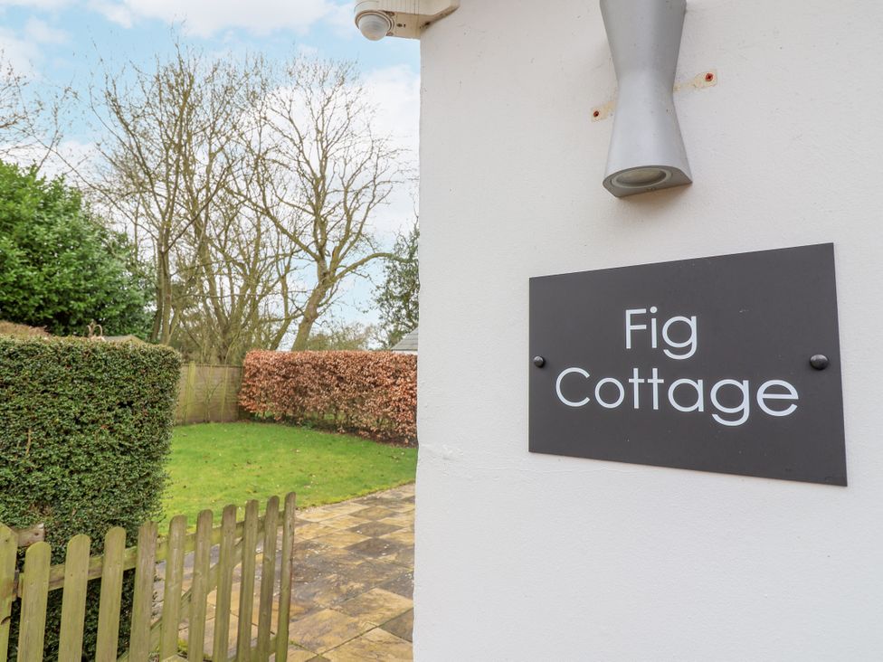 An outdoor sign for Fig Cottage with grass and hedges in the background at Fig Cottage, Pettistree