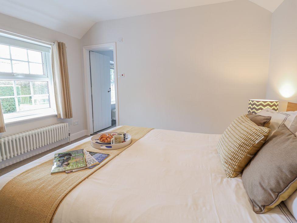 A bedroom with a bed and window at Fig Cottage, Pettistree Near Woodbridge