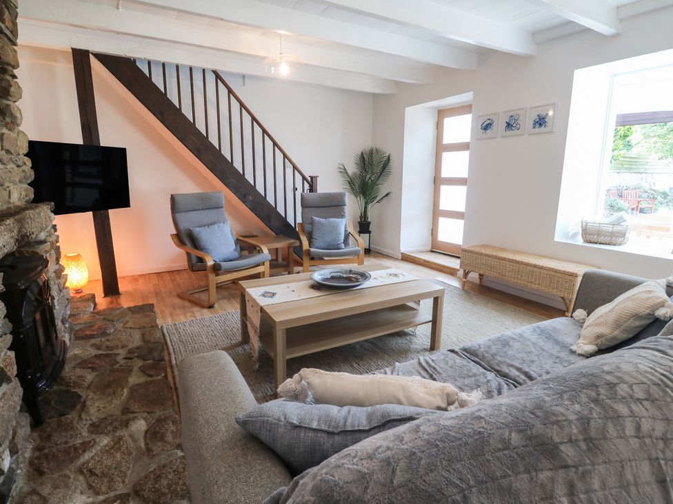 A living room with a sofa, chairs, and coffee table at Candle Croft in Tolgus Mount near Redruth
