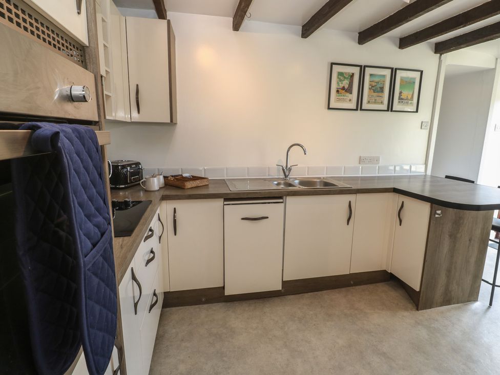 A kitchen with cabinets and appliances at Candle Croft in Tolgus Mount near Redruth