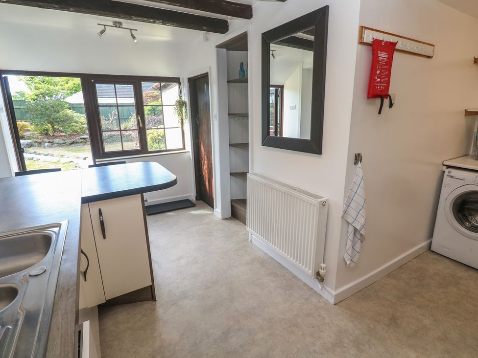 A kitchen with a sink and washing machine at Candle Croft in Tolgus Mount near Redruth