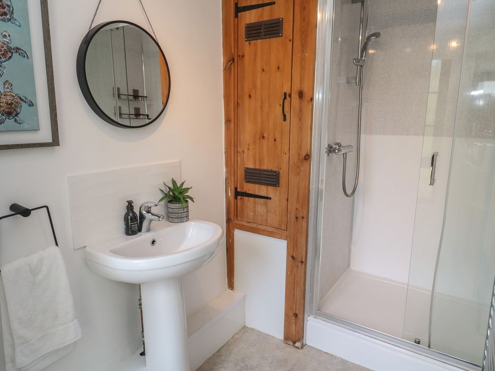A bathroom with a shower and sink at Candle Croft Tolgus Mount near Redruth
