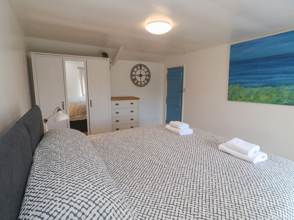 A bedroom with a bed and wardrobe at Candle Croft in Tolgus Mount near Redruth