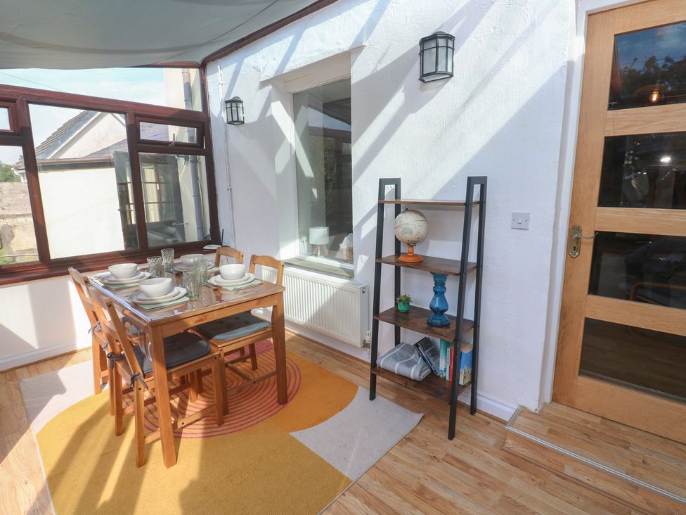 A conservatory with a dining table and chairs at Candle Croft in Tolgus Mount near Redruth