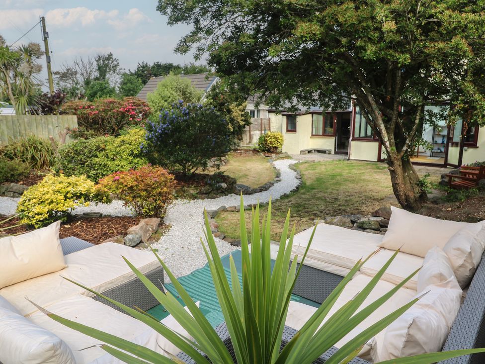 A garden with a seating area and plants at Candle Croft in Tolgus Mount near Redruth