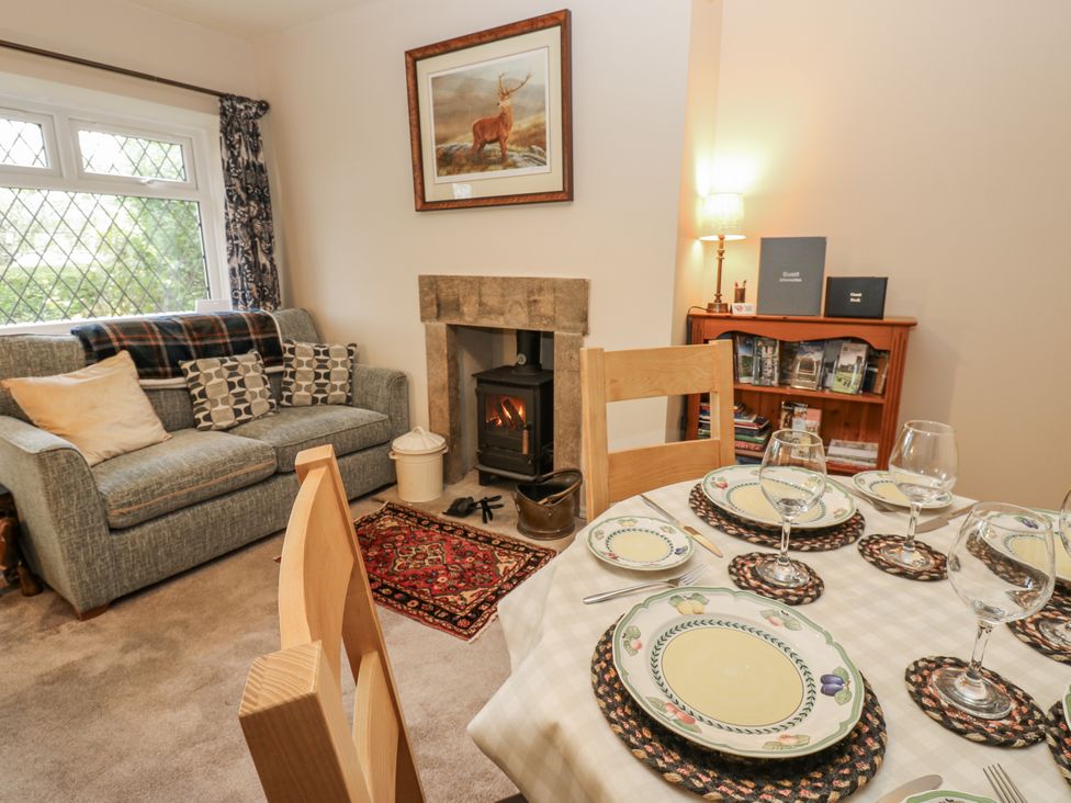 A living room with a sofa and dining table at Appletree Cottage in Richmond