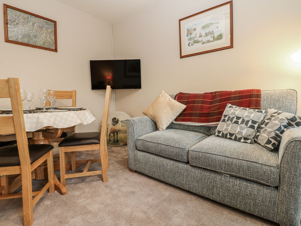 A living room with a sofa and dining area at Appletree Cottage in Richmond