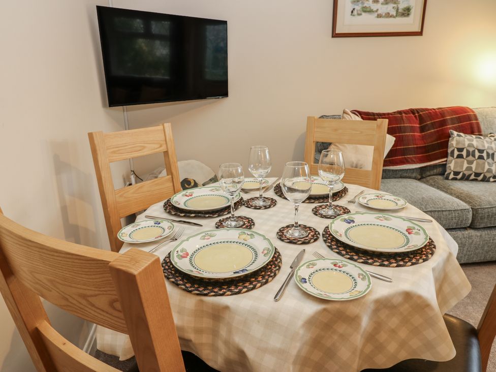 A dining table set with plates and glasses at Appletree Cottage in Richmond