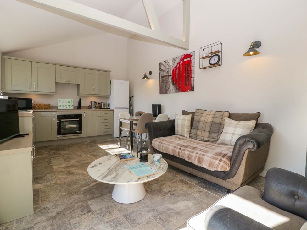 A living room with kitchen area and seating at Bottom Lodge in Penhow