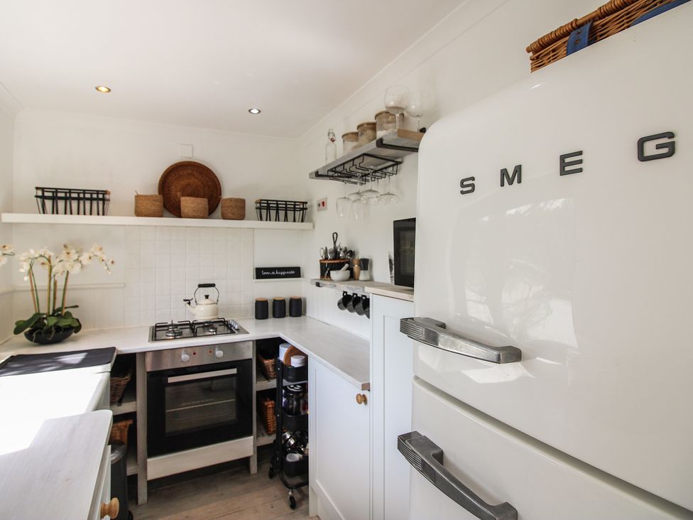 A kitchen with a refrigerator, oven, stove, and utensils at West Island in Kingsbridge