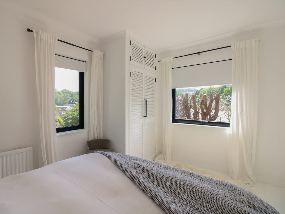 A bedroom with windows and a wardrobe at West Island in Kingsbridge