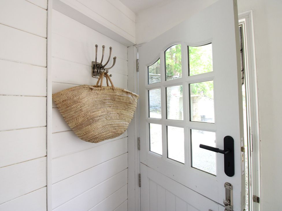An entryway with a door and a basket hanging on a hook at West Island in Kingsbridge