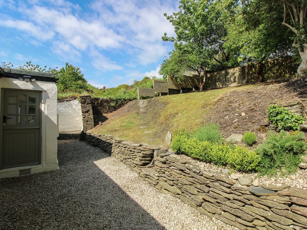 A garden with a stone wall and plants at West Island in Kingsbridge