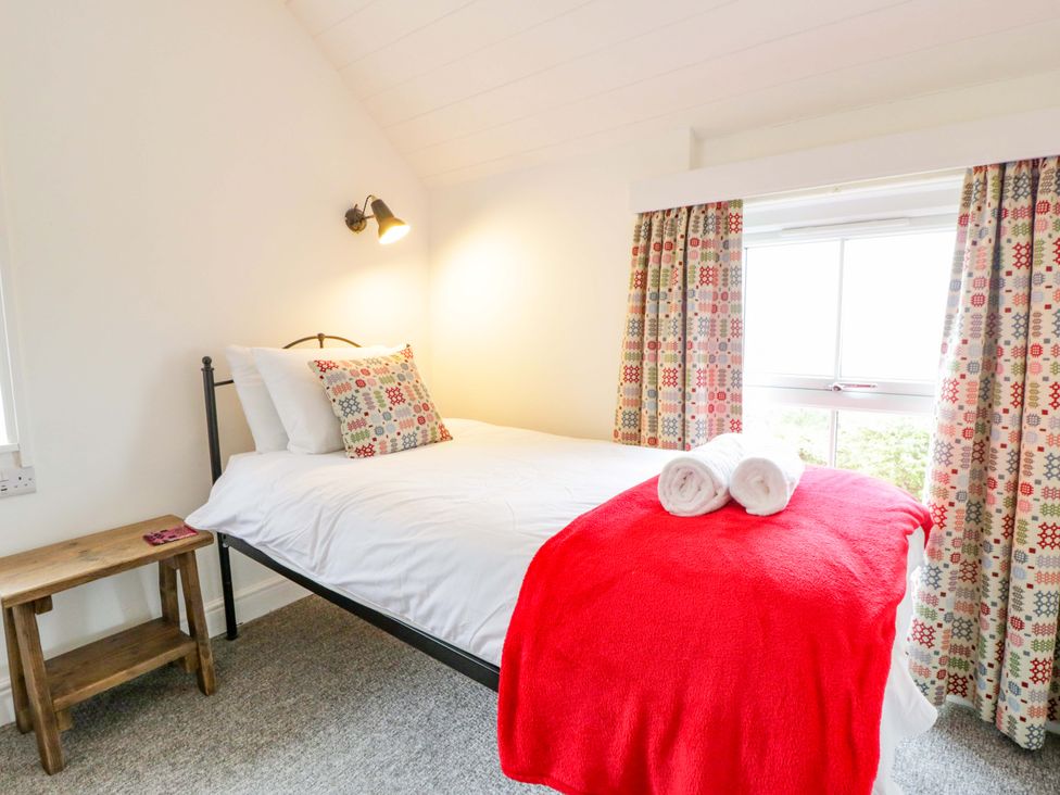 A bedroom with a bed and bedside table at Ceunant near Newport