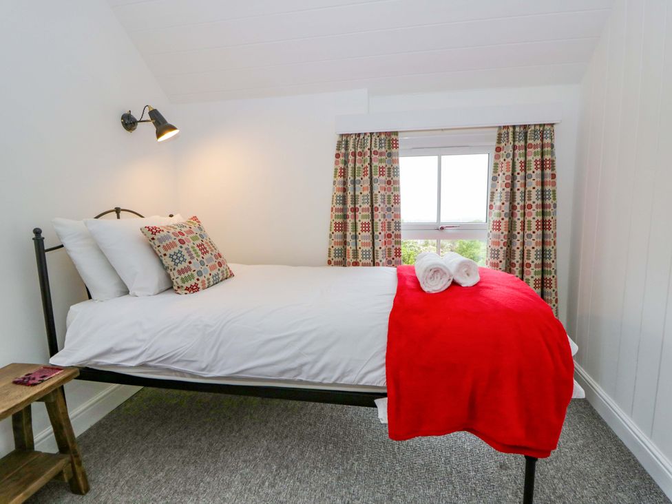 A bedroom with a bed and patterned curtains at Ceunant near Newport