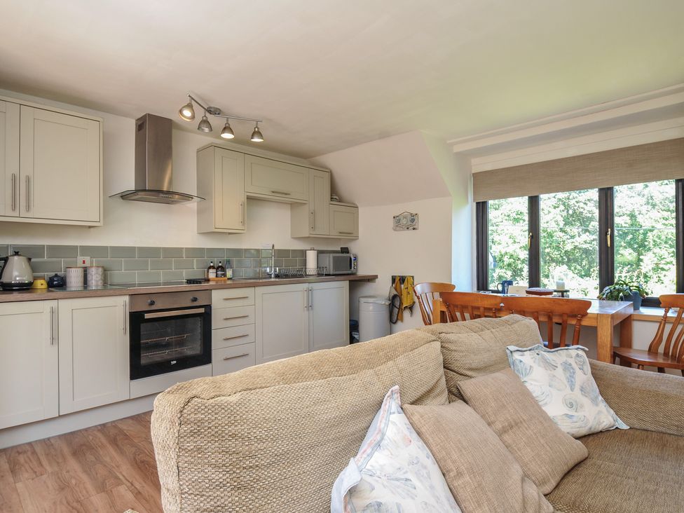 A kitchen with an oven and dining table at The Mews in Blisland