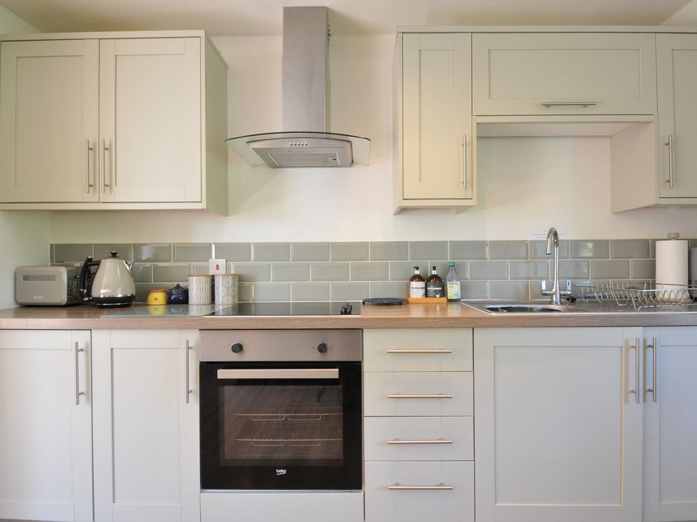 A kitchen with cabinets, oven, sink, and appliances at The Mews in Blisland