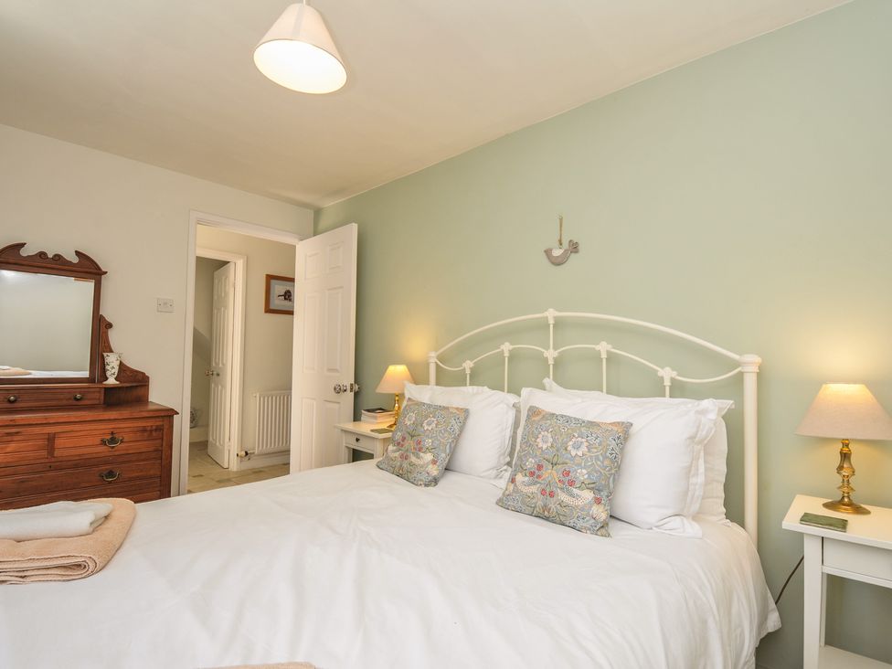 A bedroom with a bed and dresser at The Mews in Blisland