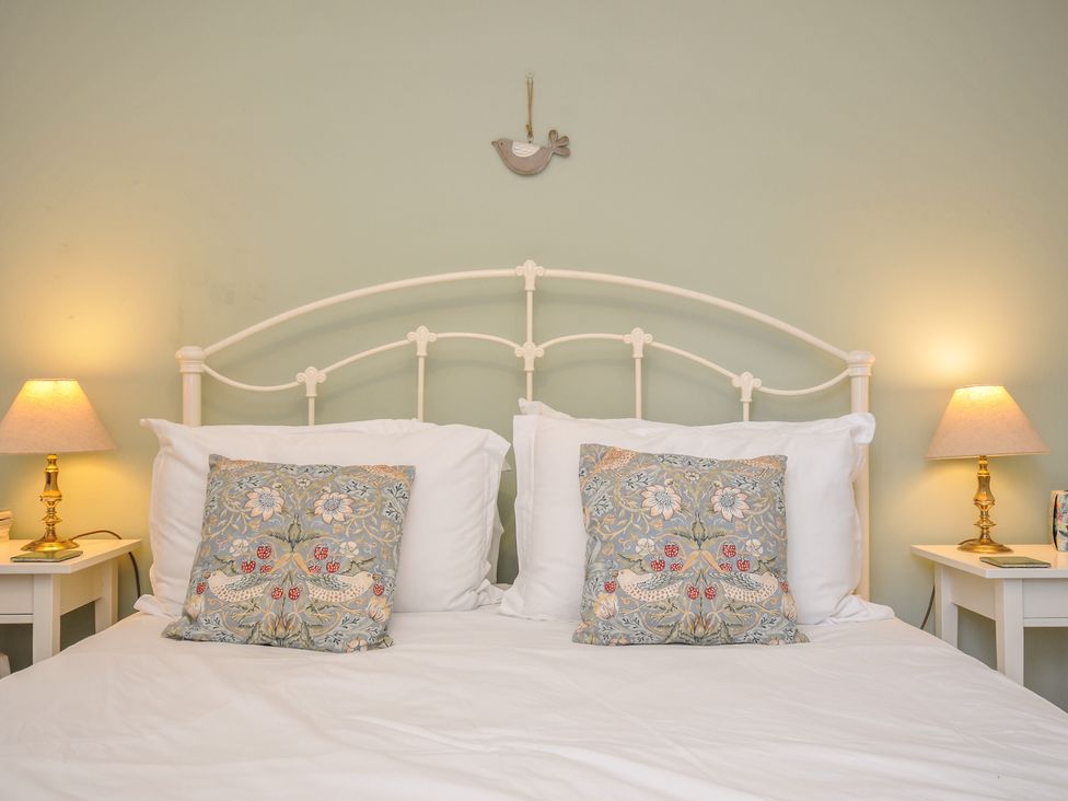 A bedroom with a bed and bedside tables at The Mews in Blisland
