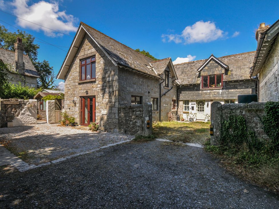 A house with a driveway and stone wall at The Mews in Blisland