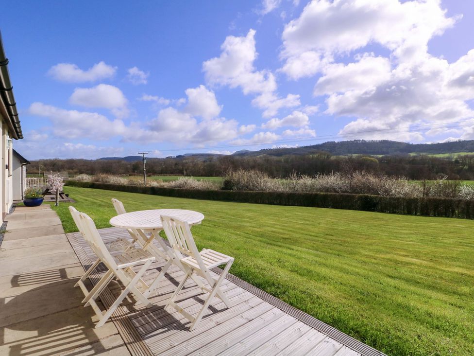 A garden with a table and chairs at Sunny Cottage in Brecon