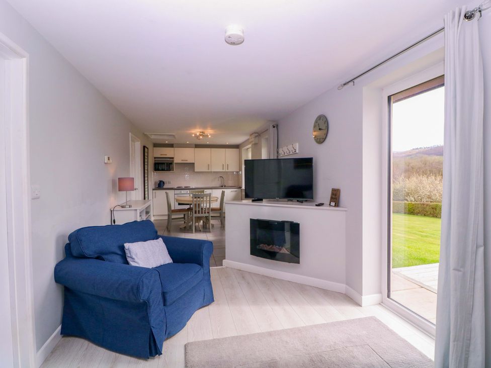 A living room with a sofa and television at Sunny Cottage in Brecon